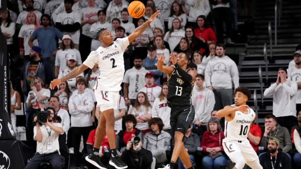 UCF Knights guard C.J. Kelly (13) passes as Cincinnati Bearcats guard Landers Nolley II (2) defends in the second half of a college basketball game between the UCF Knights and the Cincinnati Bearcats, Saturday, Feb. 4, 2023, at Fifth Third Arena in Cincinnati. The Cincinnati Bearcats won, 73-64. Ucf Knights At Cincinnati Bearcats Feb 4 0253